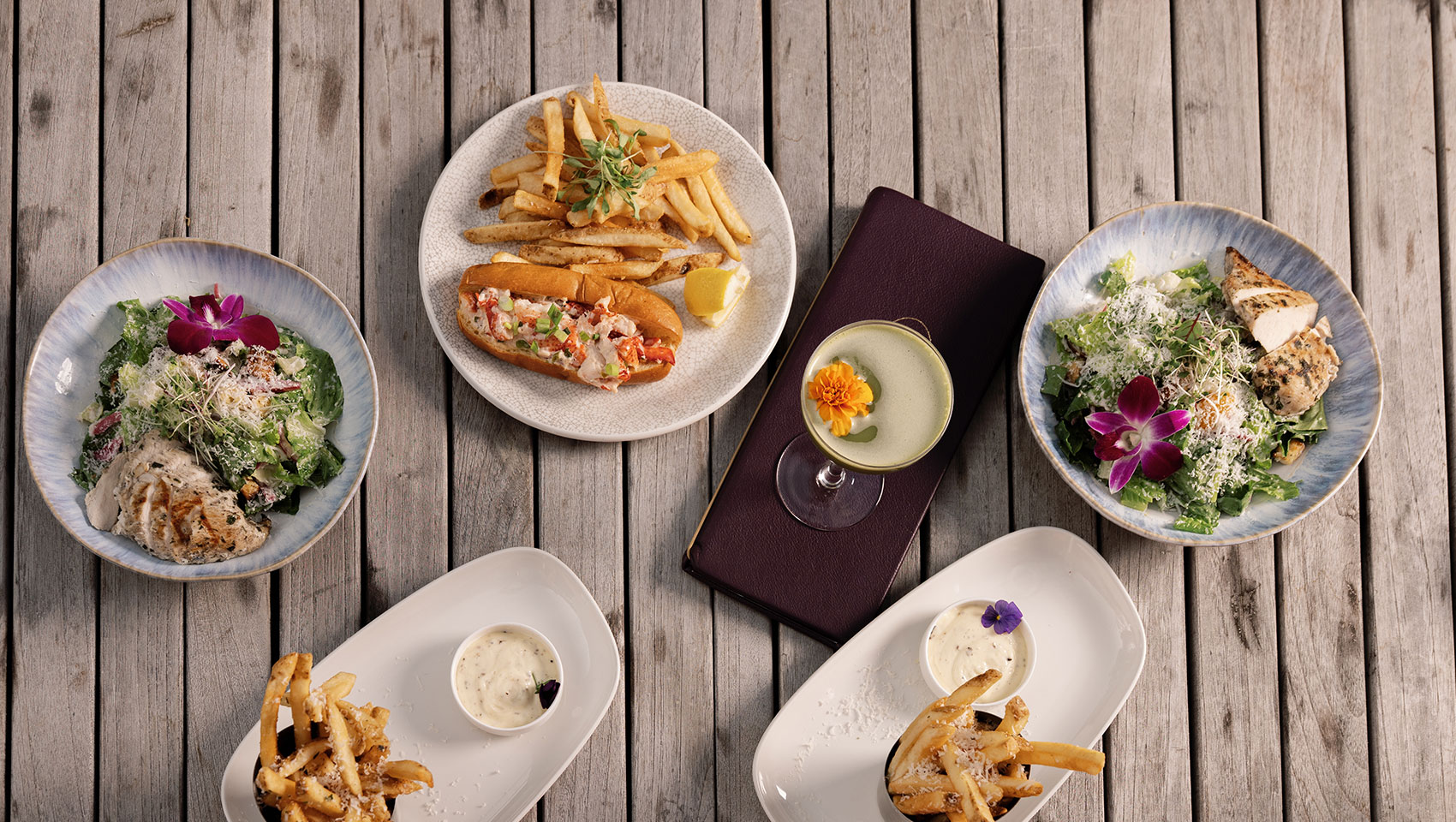 overhead view of dishes and cocktails at astrea rooftop